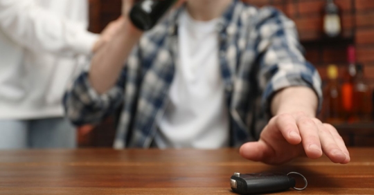 drunk man reaching for keys at bar