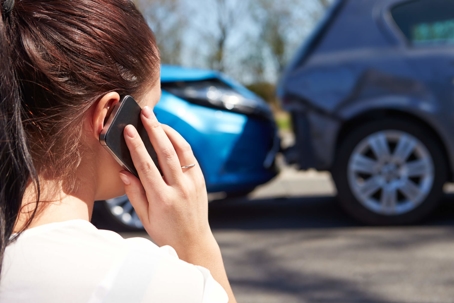 Woman on phone looking at car accident